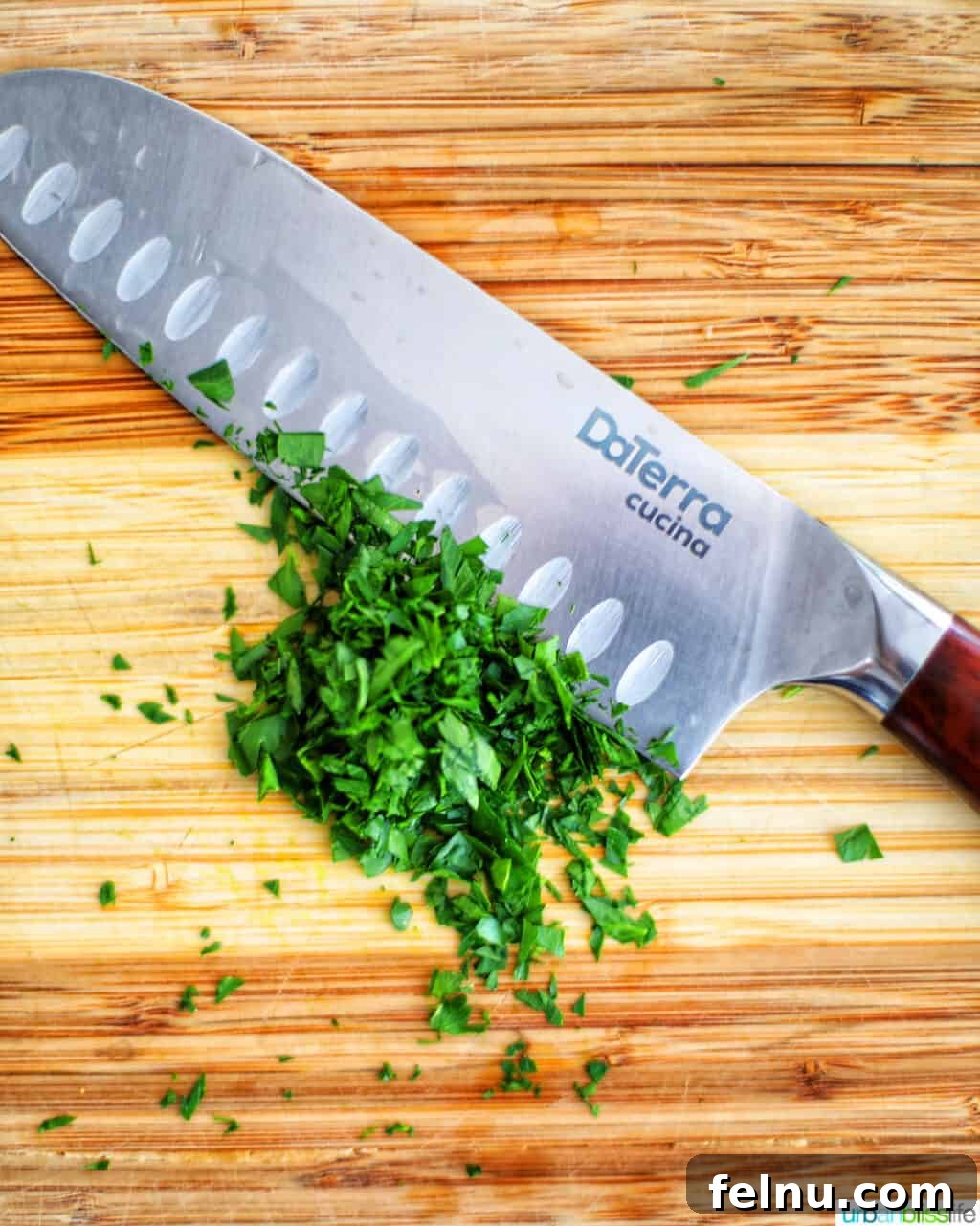 Sharpen Your Skills: The Definitive Guide to Kitchen Knives 4 A sharp santoku knife positioned next to fresh herbs, symbolizing its utility for precise cuts and preparation.