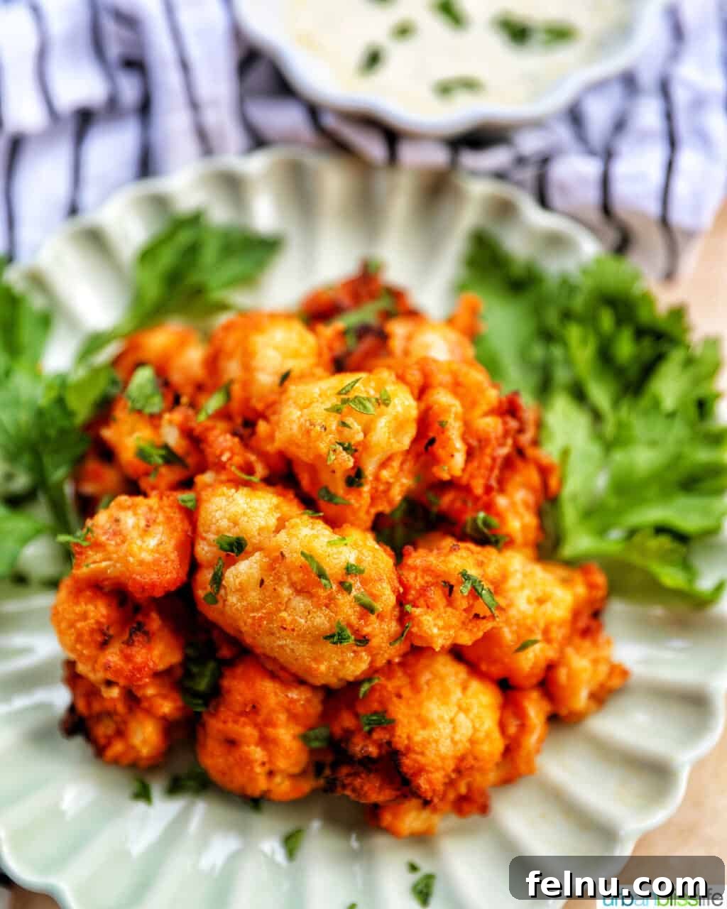 Fiery Air-Fried Cauliflower Poppers 3 A side view of crispy air fryer buffalo cauliflower in a bowl, showing its texture and vibrant color.
