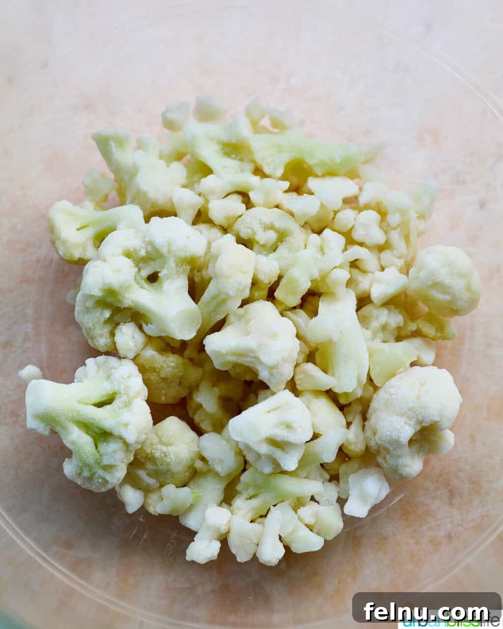 Fiery Air-Fried Cauliflower Poppers 6 Frozen cauliflower florets in a large mixing bowl.