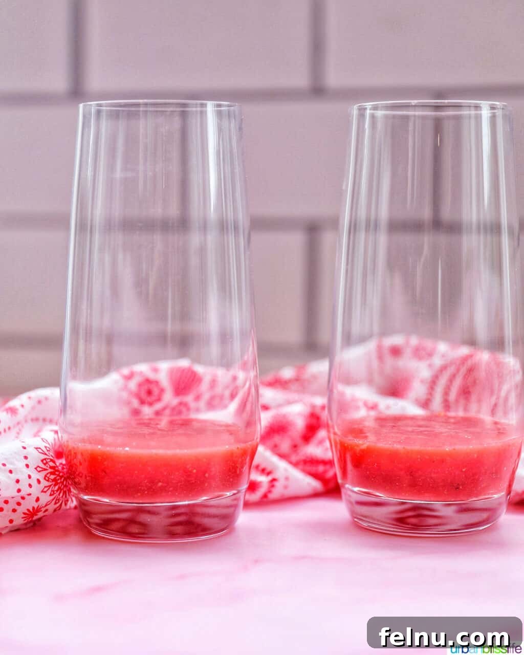 Pouring strawberry jam into two glasses