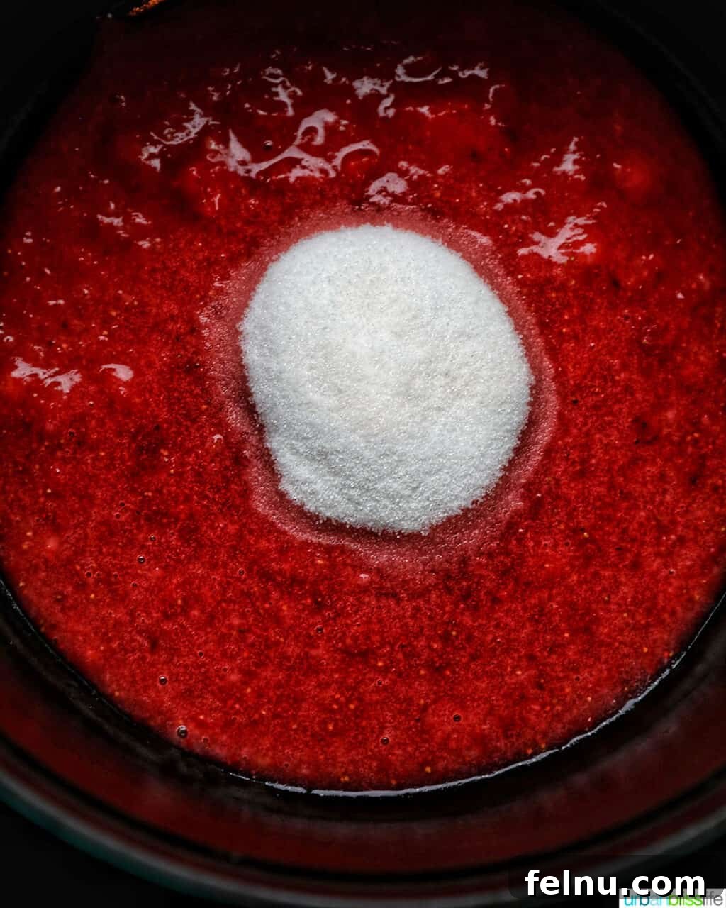 Adding sugar to strawberries in a pot