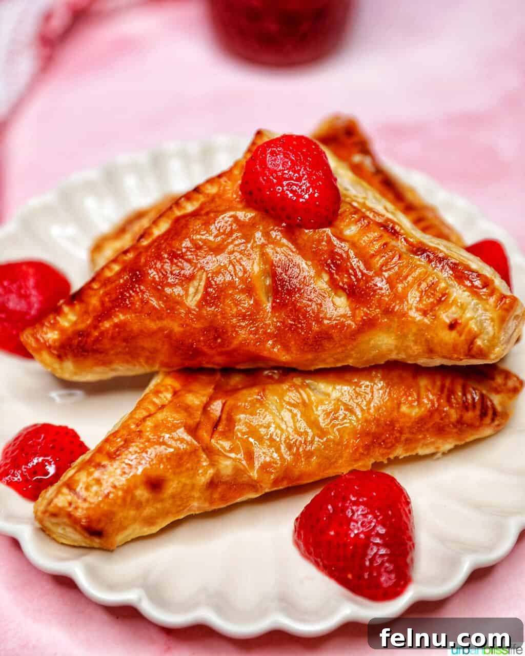 Flaky Strawberry Pockets 17 air fryer strawberry turnovers stacked on plate with strawberries