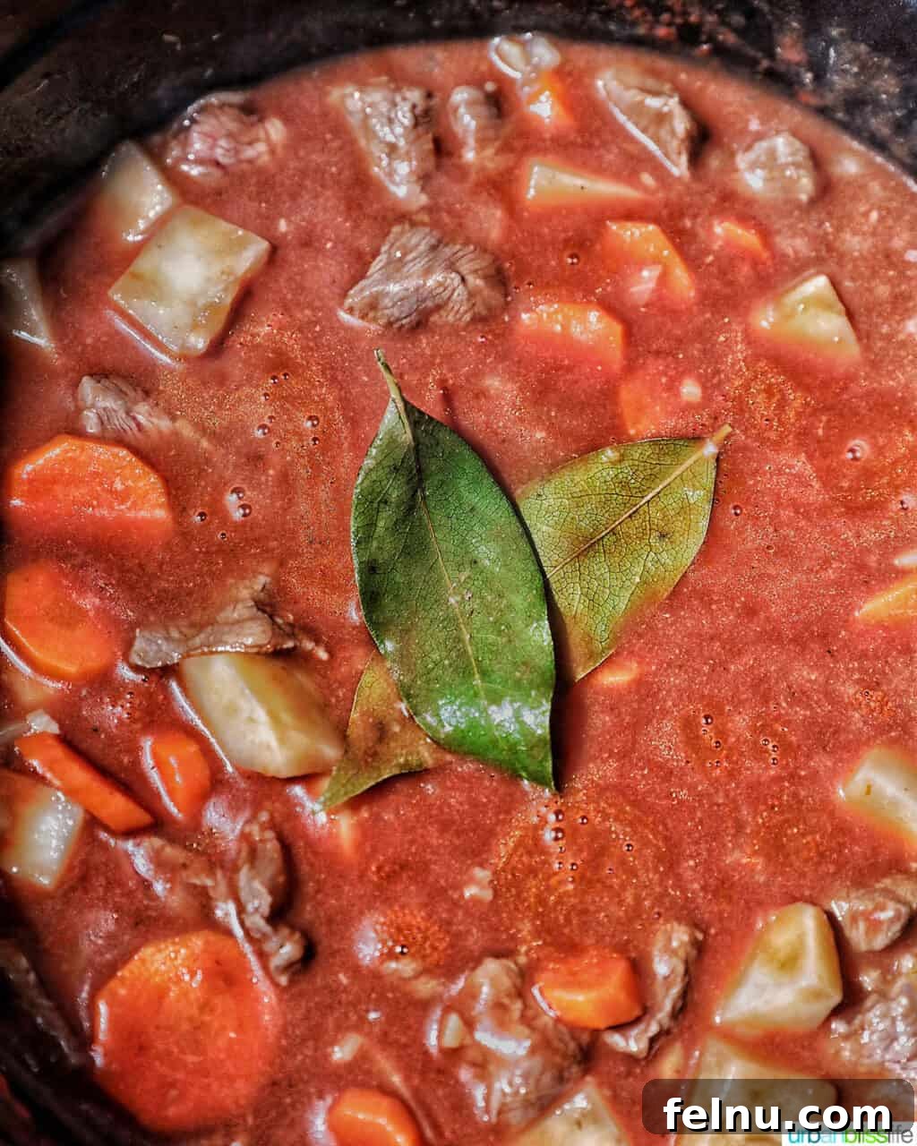 Adding bay leaves to beef caldereta.