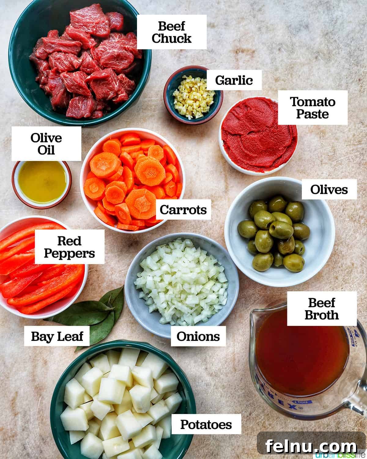 Bowls of ingredients for beef caldereta, including steak, carrots, potatoes, and red bell peppers.