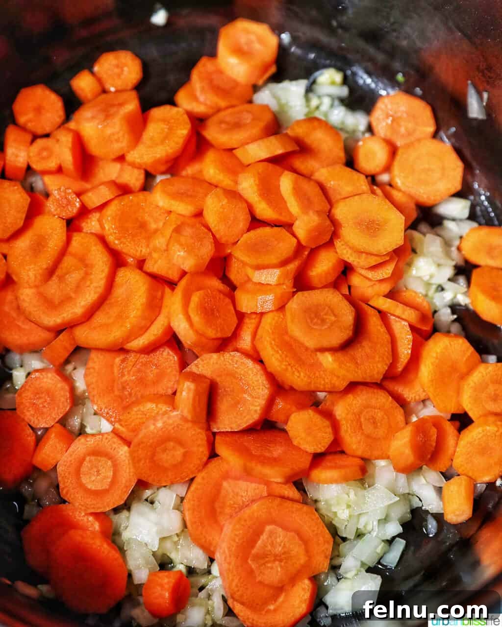 Adding carrots to beef caldereta.