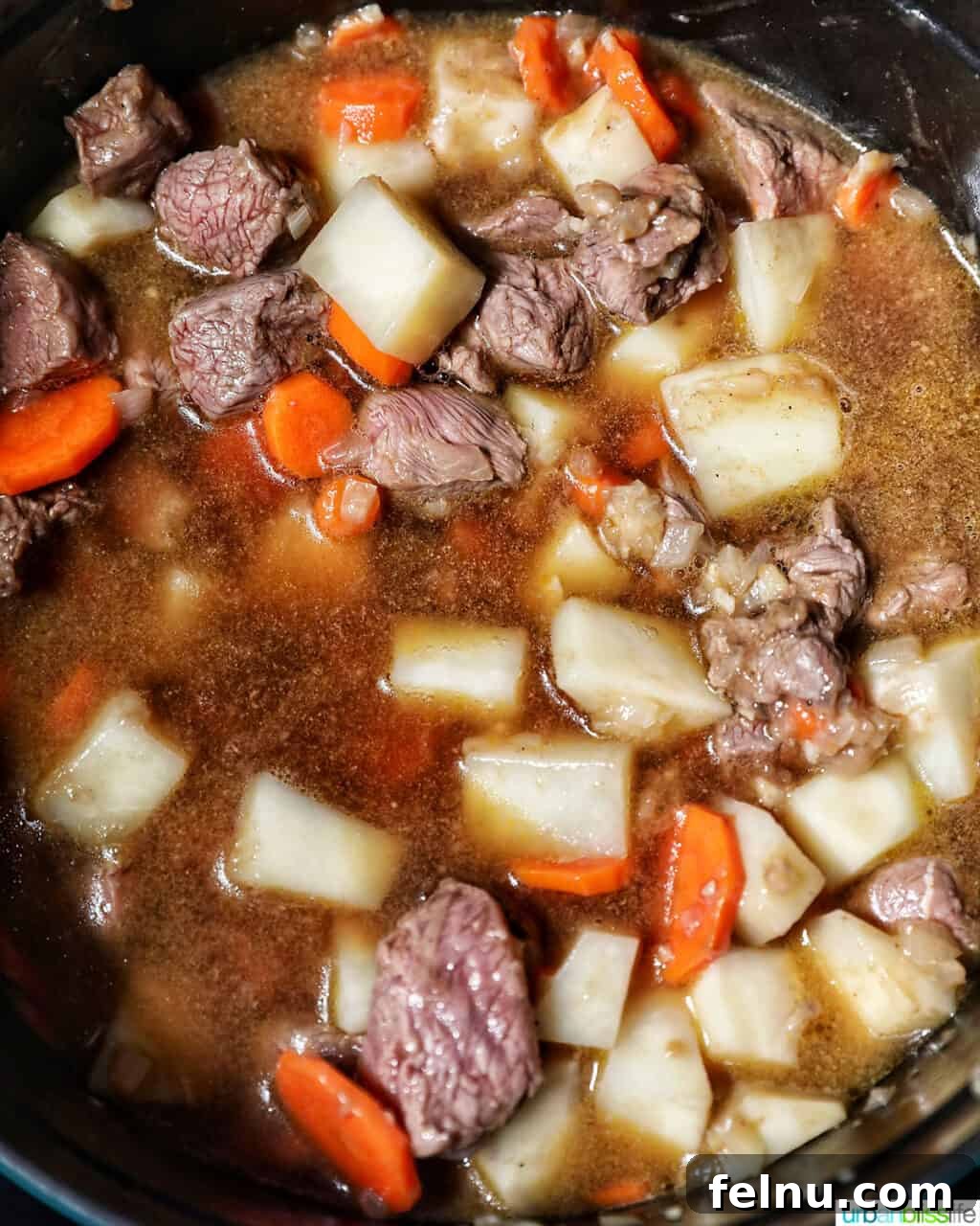 Adding beef broth to beef caldereta.