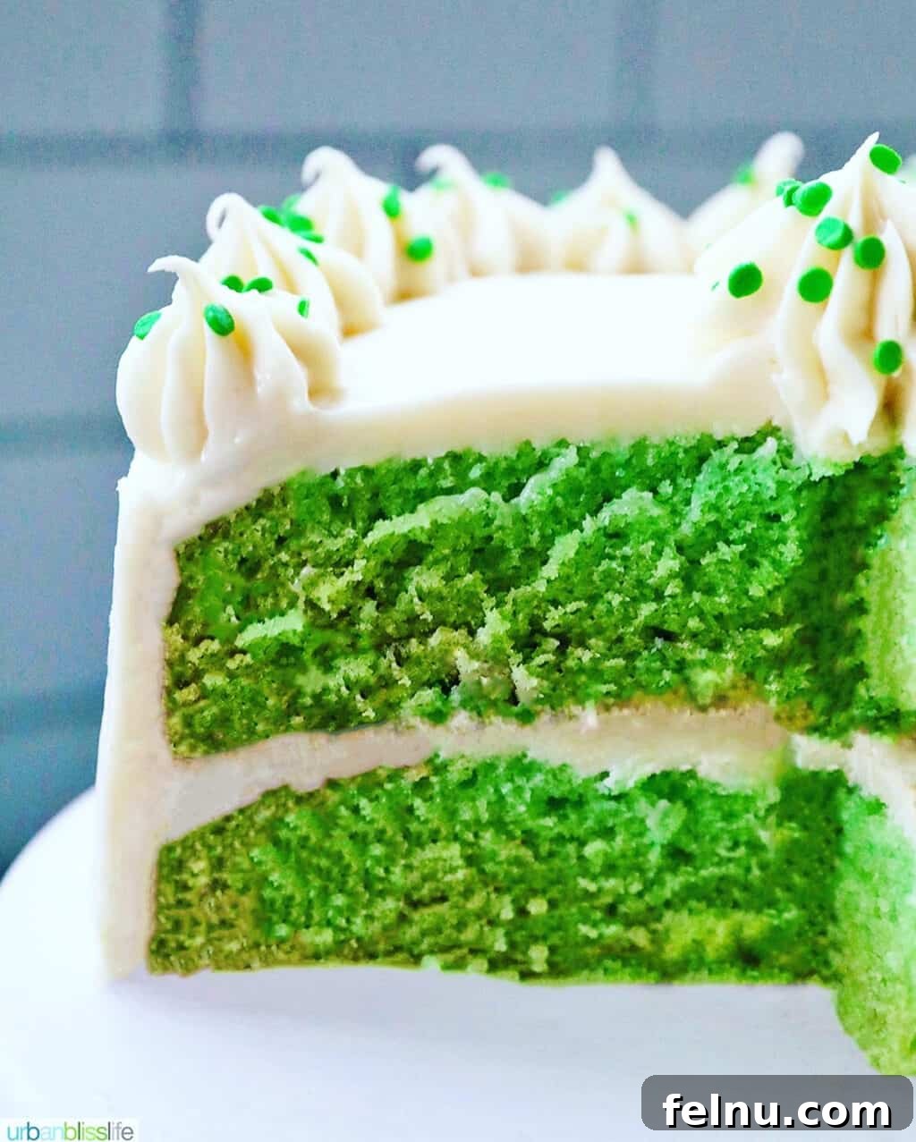 Emerald Velvet Delight with Tangy Cream Cheese 2 Green velvet cake with a slice removed, showing its vibrant green interior and rich cream cheese frosting.