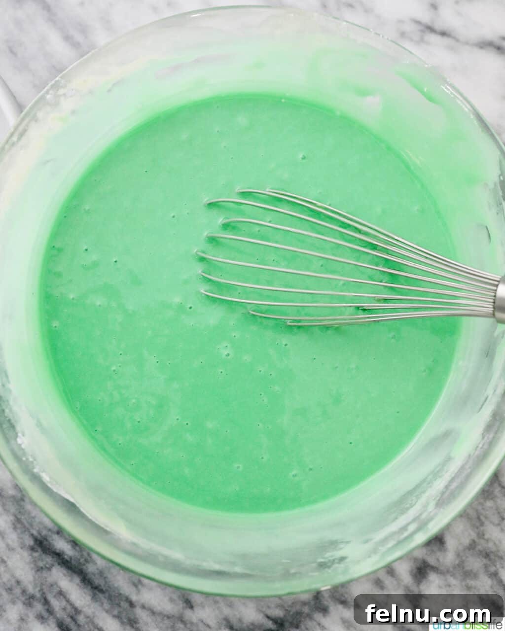 Emerald Velvet Delight with Tangy Cream Cheese 16 Mixing bowl filled with vibrant green cake batter.