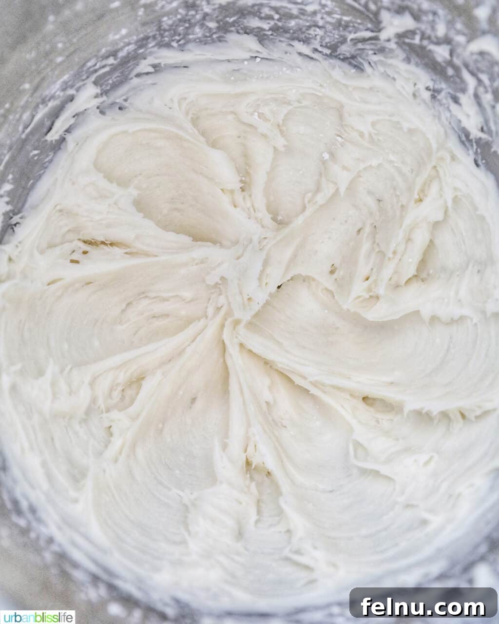 Emerald Velvet Delight with Tangy Cream Cheese 22 Smooth and creamy cream cheese frosting in a stand mixer bowl.
