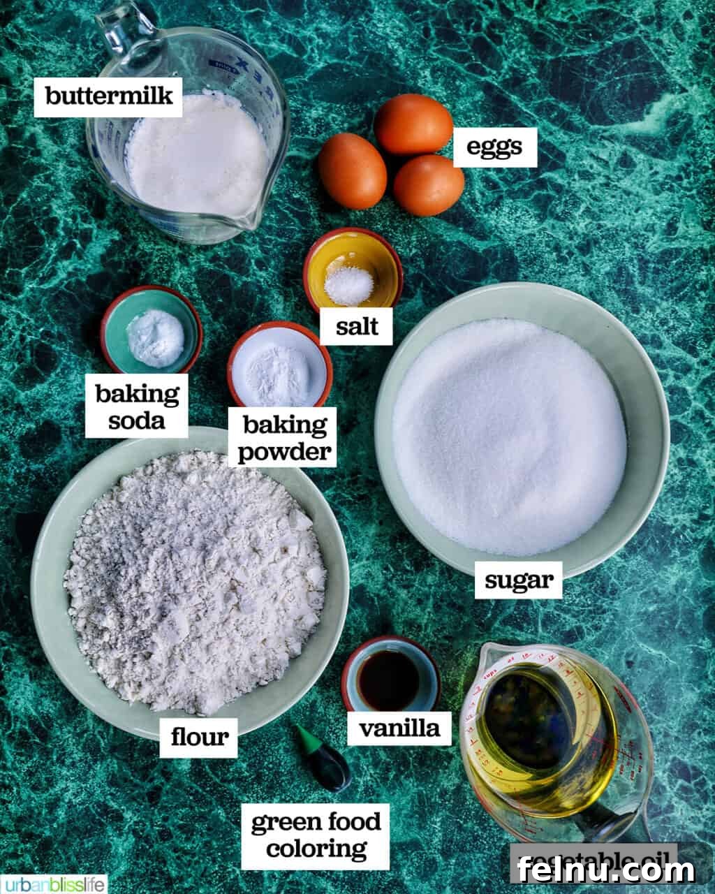 Emerald Velvet Delight with Tangy Cream Cheese 5 Various ingredients laid out for making green velvet cake, including flour, sugar, eggs, buttermilk, and green food coloring.