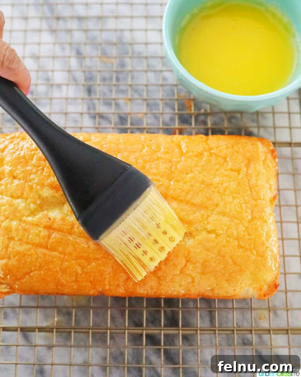 Taisan: Fluffy Filipino Chiffon Cake Perfection 20 Brushing melted butter onto the top of a freshly baked Taisan cake
