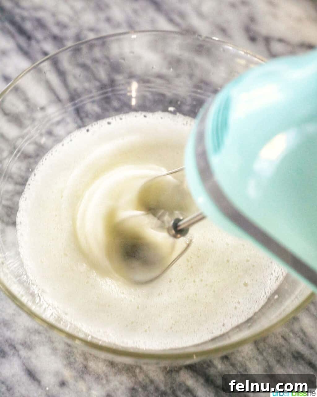 Taisan: Fluffy Filipino Chiffon Cake Perfection 4 A hand mixer whipping meringue in a large bowl, demonstrating a key step in Taisan preparation