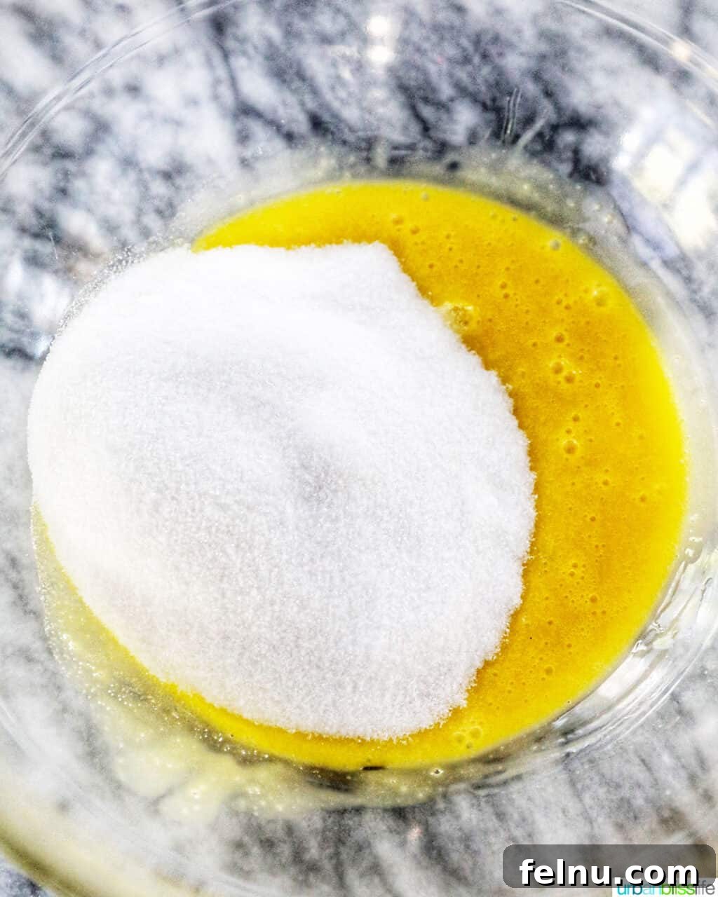 Taisan: Fluffy Filipino Chiffon Cake Perfection 9 Egg yolks mixed with sugar in a bowl, forming a pale yellow mixture