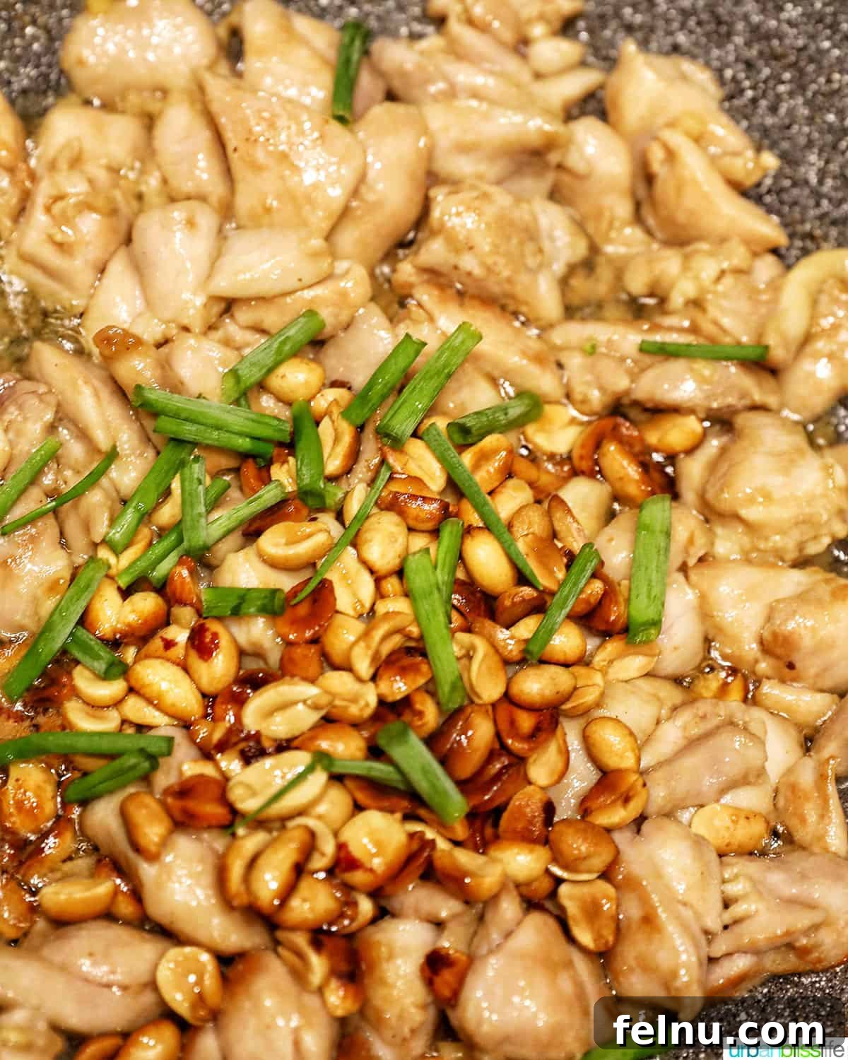 Weeknight Kung Pao Chicken 18 Adding green onions to the Kung Pao Chicken with peanuts