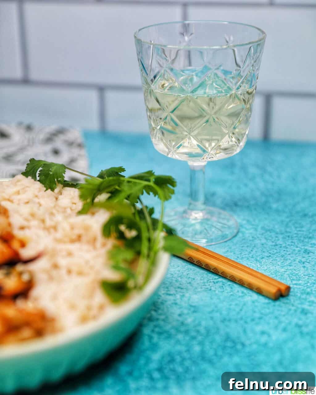 Weeknight Kung Pao Chicken 21 A glass of white wine next to a plate of Kung Pao Chicken and rice