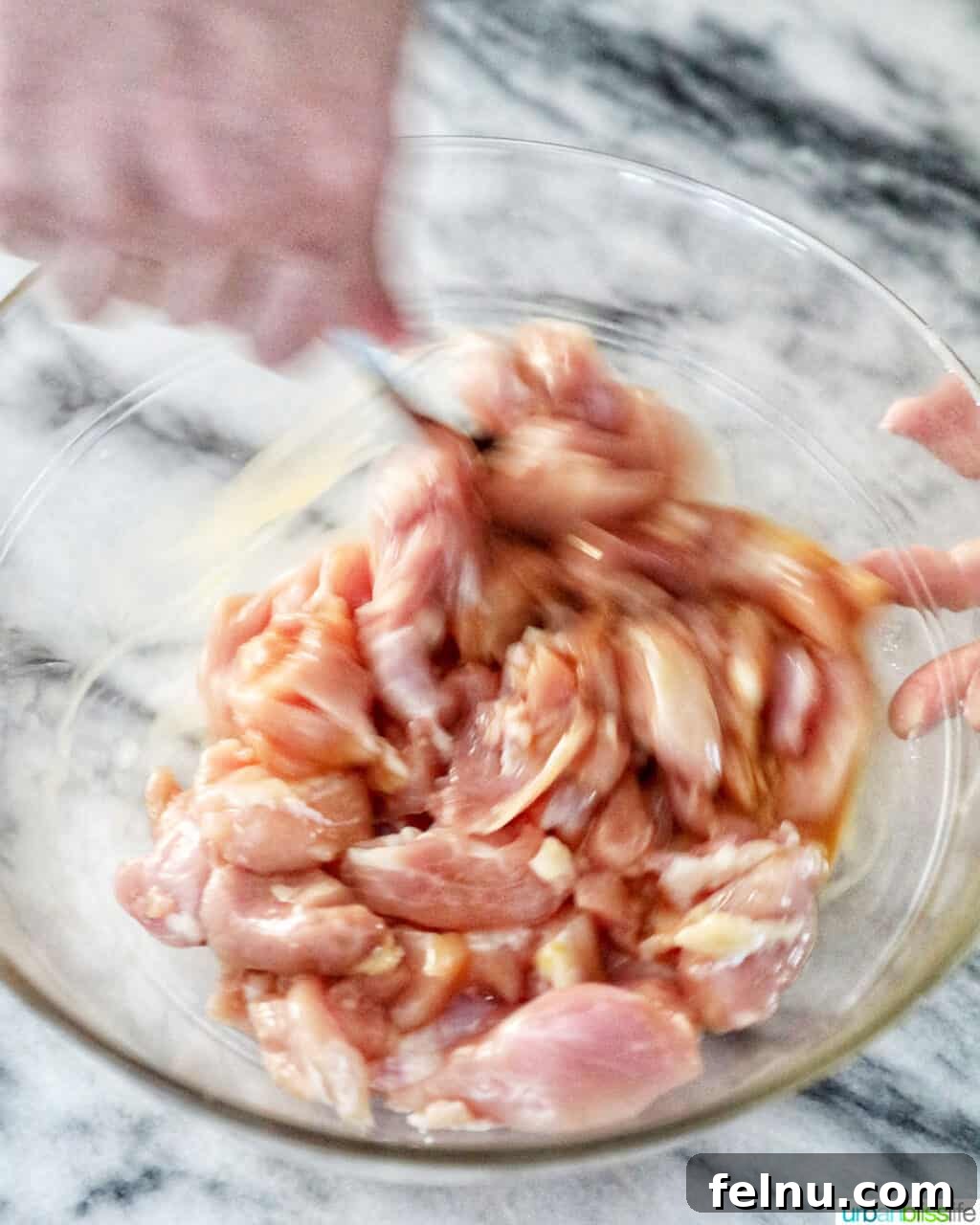 Weeknight Kung Pao Chicken 9 Coating raw chicken pieces with Kung Pao marinade in a bowl