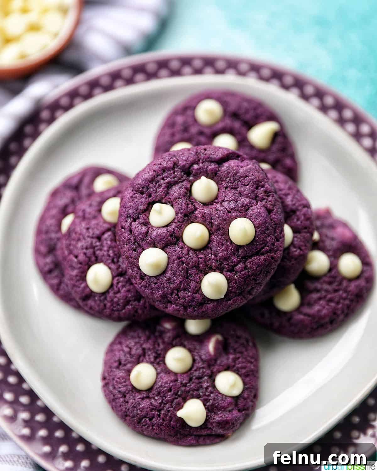 Ube and White Chocolate Dream Cookies 3 A close-up of Ube White Chocolate Chip Cookies stacked high, showcasing their vibrant purple interior and delicious white chocolate chips.