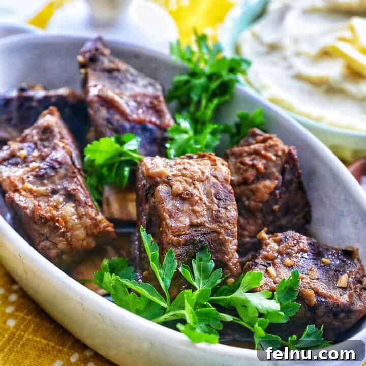 filipino short ribs adobo in a serving dish with herbs.