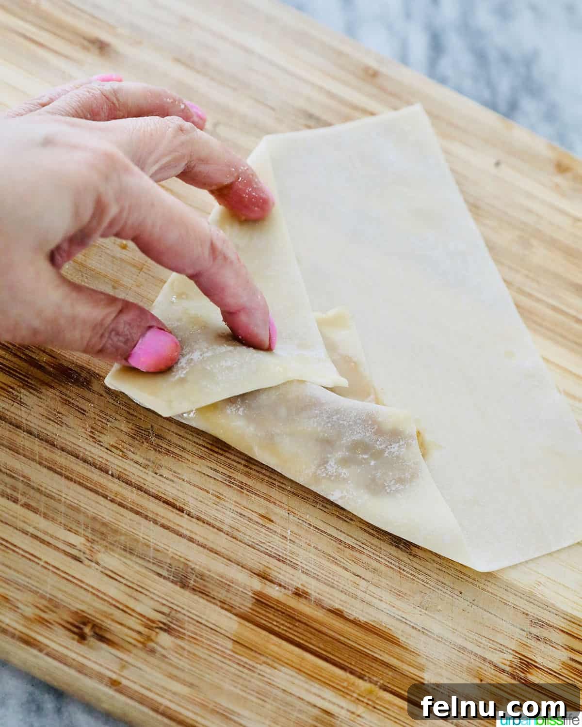 Effortless Filipino Turon: Crispy Banana Lumpia Perfection 13 Folding Filipino turon banana lumpia wrapper from the side.