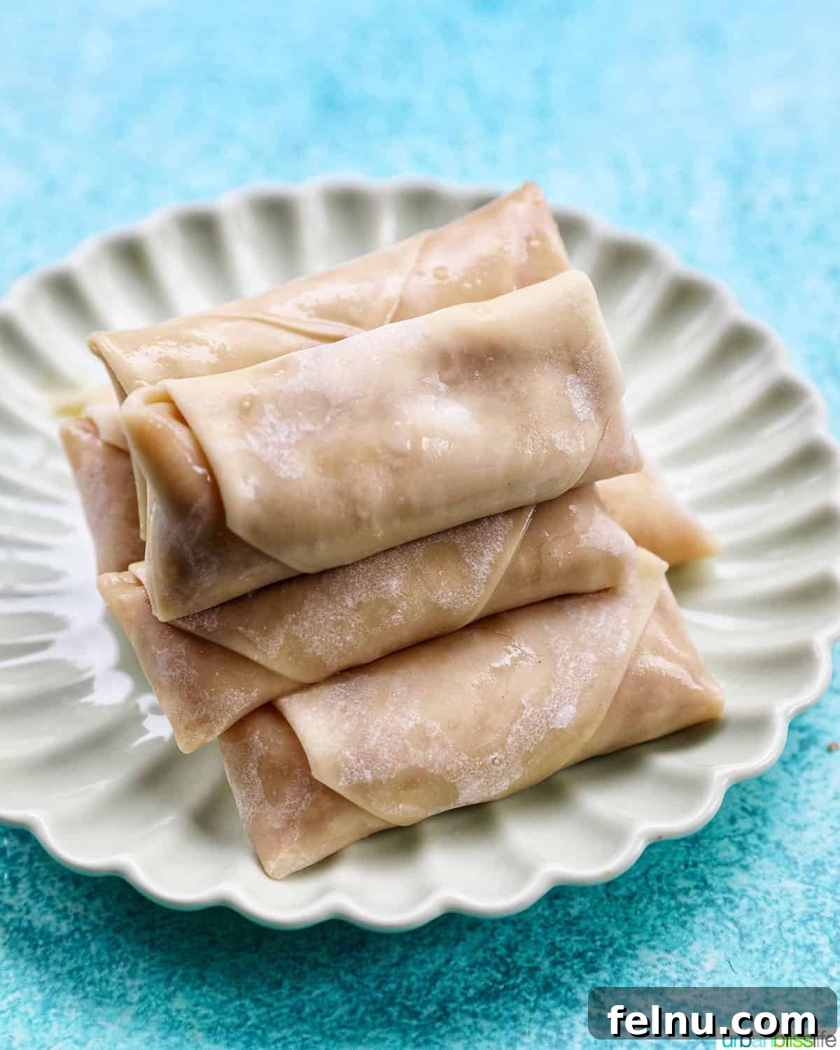Effortless Filipino Turon: Crispy Banana Lumpia Perfection 16 Rolled up Filipino turon banana lumpia on a plate.