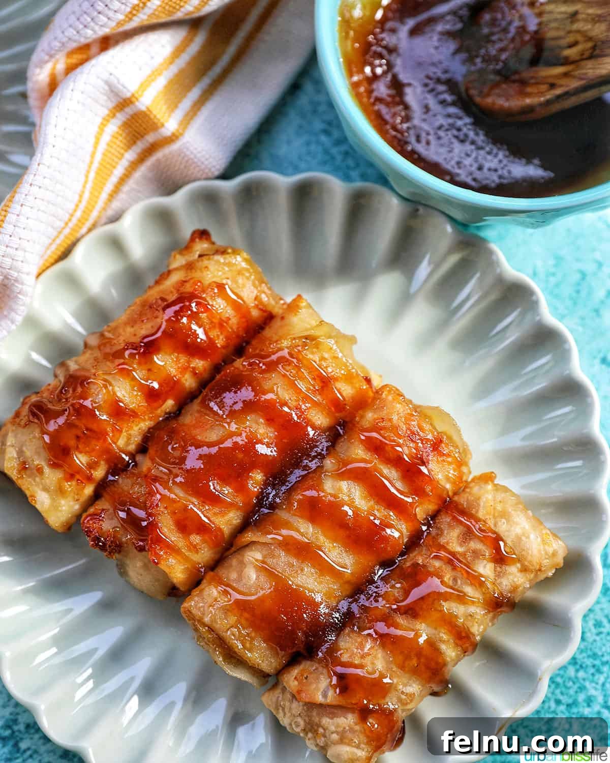 Effortless Filipino Turon: Crispy Banana Lumpia Perfection 23 Close-up of a plate of Filipino turon banana lumpia with caramel drizzle.