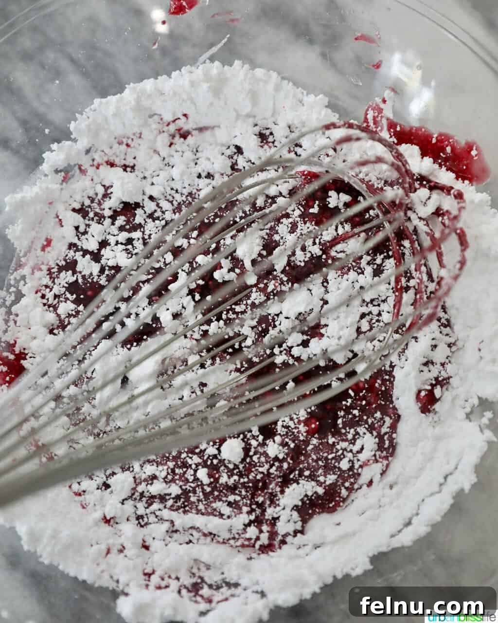 Adding powdered sugar to blackberries to make a glaze