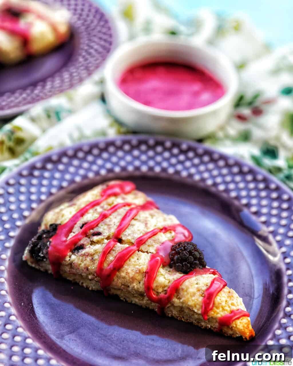 Blackberry scones with blackberry glaze on purple plate