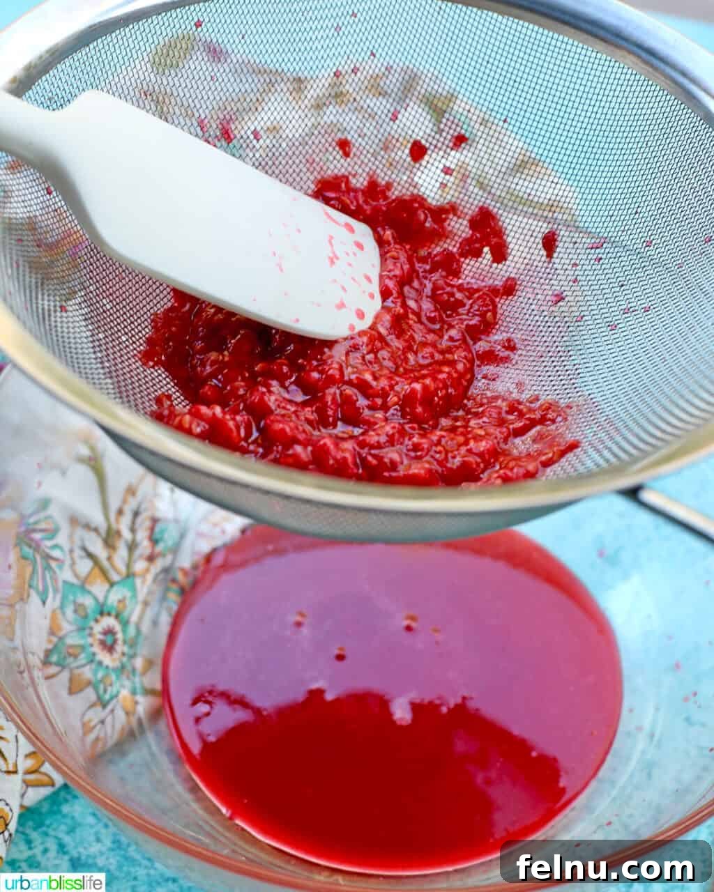 Raspberry Sparklers 13 Straining raspberries through a strainer into a bowl.