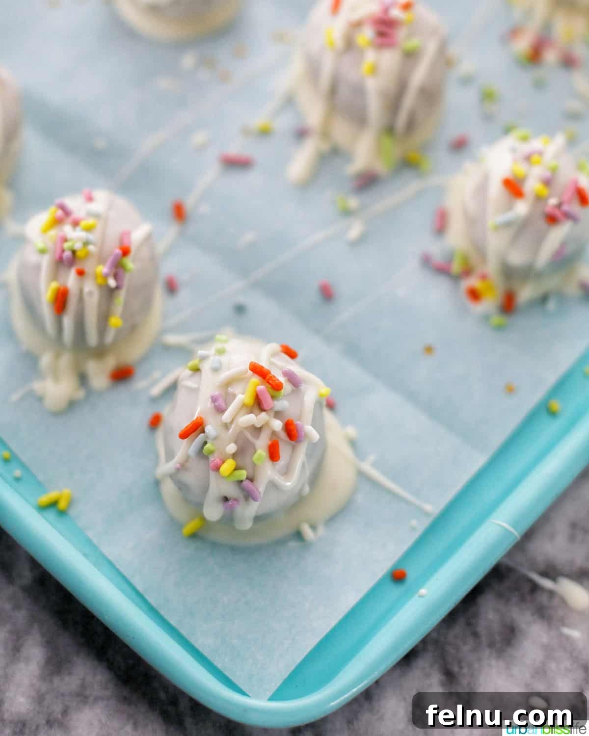 Decadent Cookie Dough Delights 16 chocolate chip cookie dough truffles with spring sprinkles setting on baking sheet