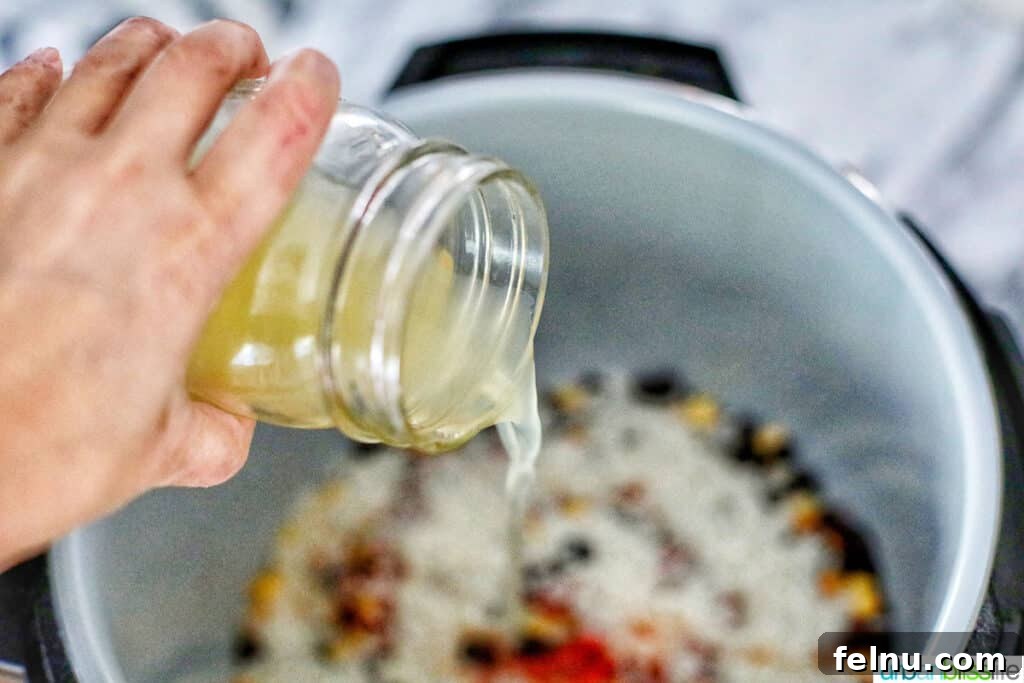 Vegetarian Burrito Bowl: A Speedy Instant Pot Delight 9 pouring vegetable broth into the instant pot