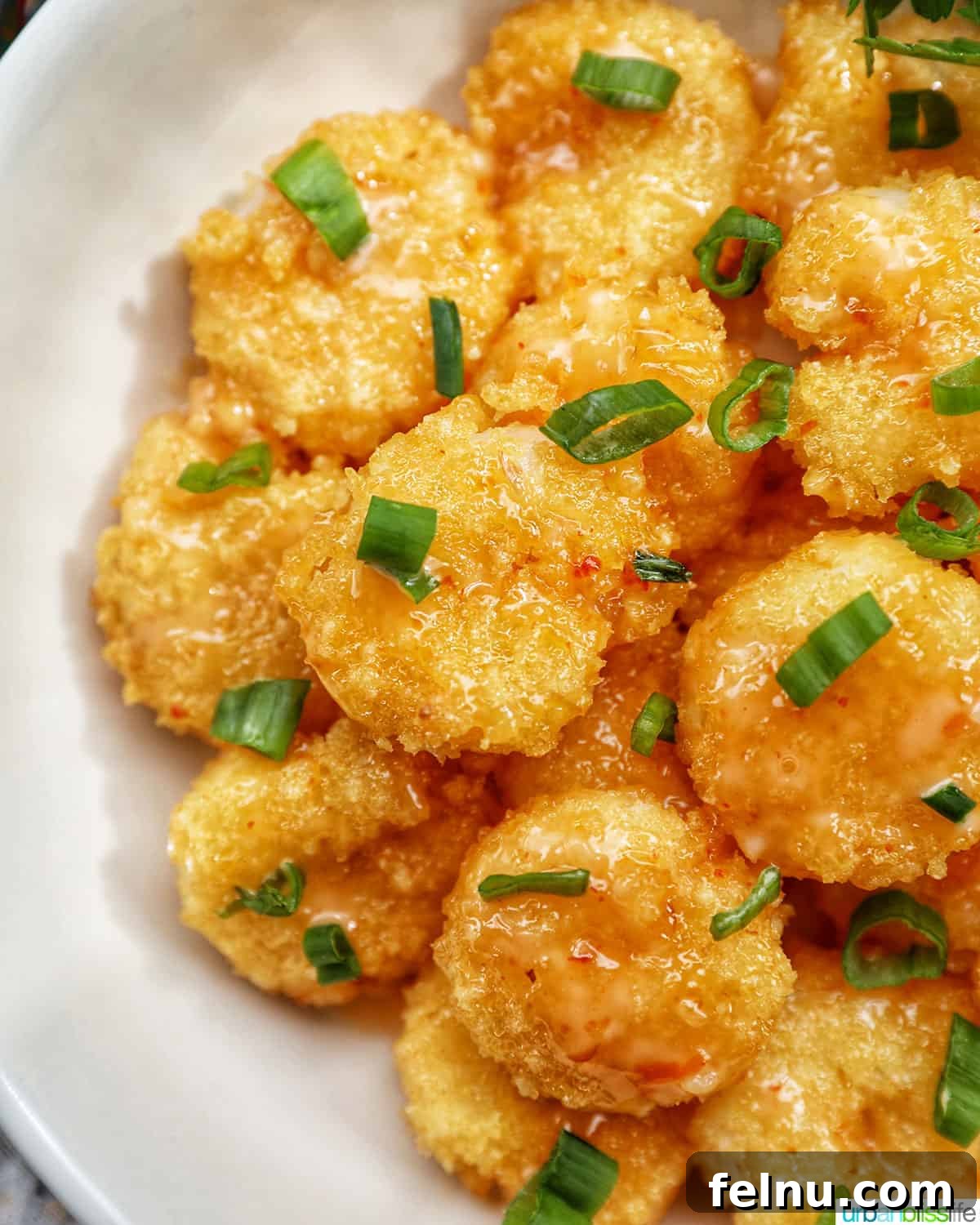 Bang Bang Shrimp: An Air Fryer Sensation 3 Air fryer bang bang shrimp garnished with green onions in a white bowl.