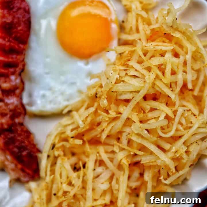 air fryer hash browns with a fried egg and bacon.
