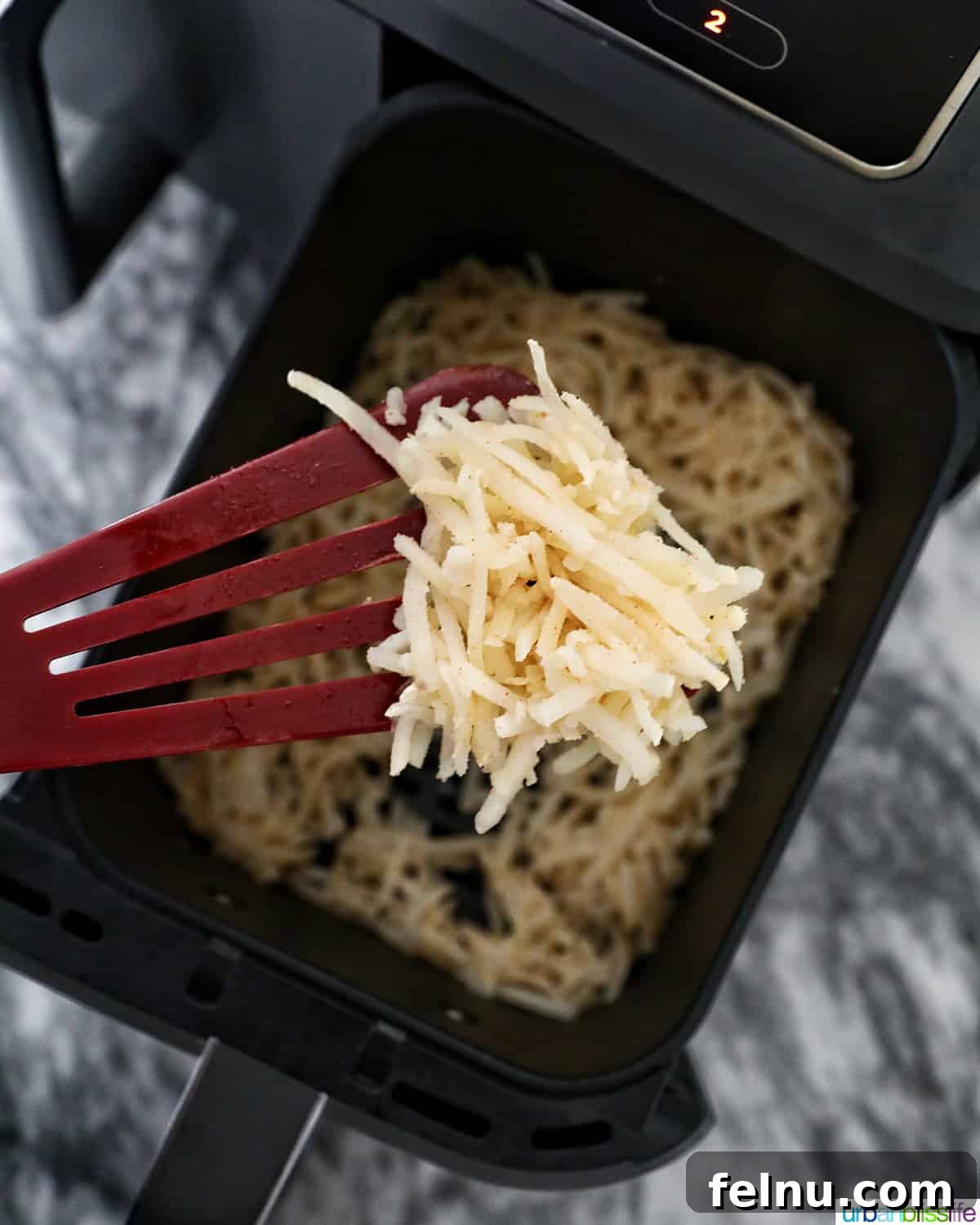 Air-Fried Hash Brown Bliss 9 Crispy air fryer hash browns being removed with a spatula