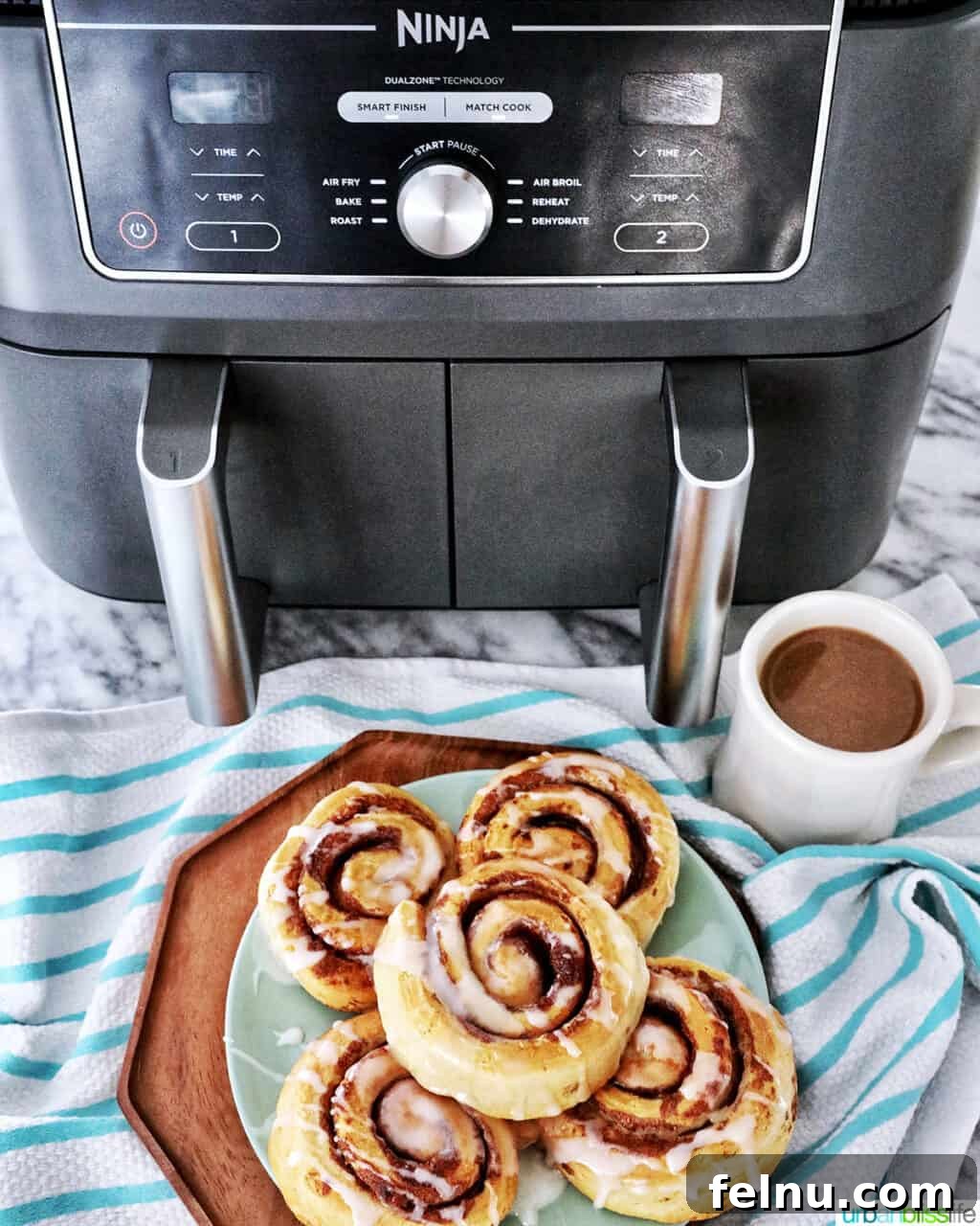 Golden Air Fryer Cinnamon Swirls 3 Air fried cinnamon rolls resting in a Ninja Foodi air fryer basket