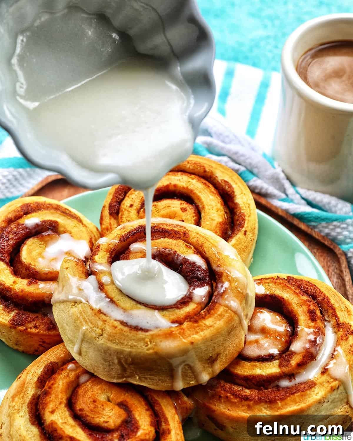 Golden Air Fryer Cinnamon Swirls 9 Icing being poured over warm air fried cinnamon rolls