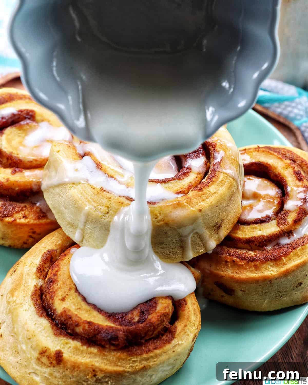 Golden Air Fryer Cinnamon Swirls 10 Close-up of icing generously drizzled over hot cinnamon rolls