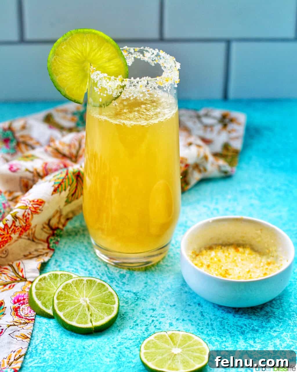 Sparkling Margarita Bliss 3 Champagne Margarita in a glass with lime slices on the rim