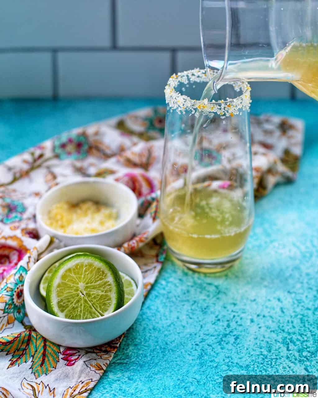 Sparkling Margarita Bliss 7 Pouring a Champagne Margarita into a glass, with limes nearby