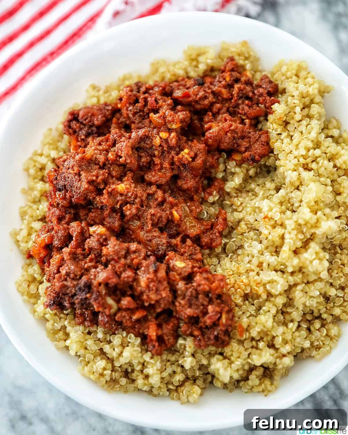Adding chorizo over quinoa in a bowl
