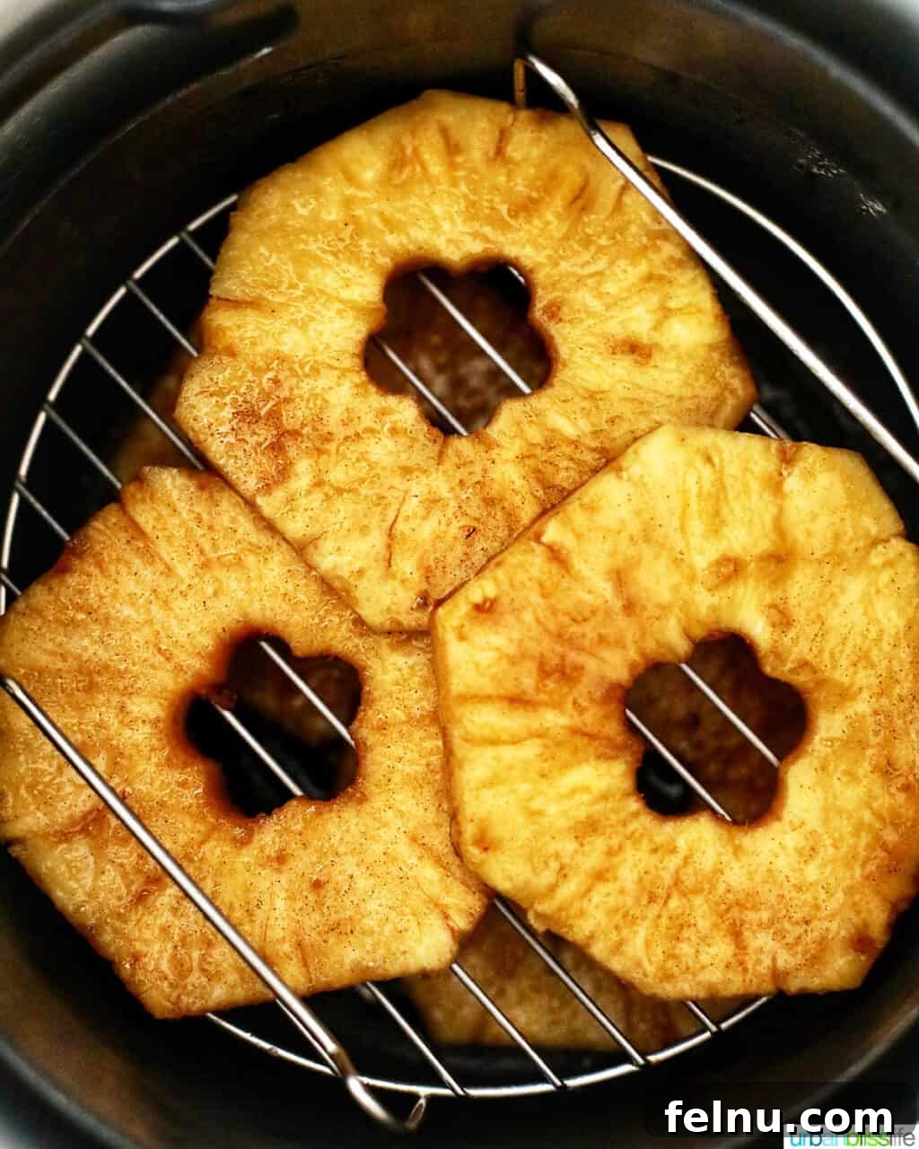 Golden Air Fryer Pineapple 11 Air fryer basket filled with cooked pineapple slices