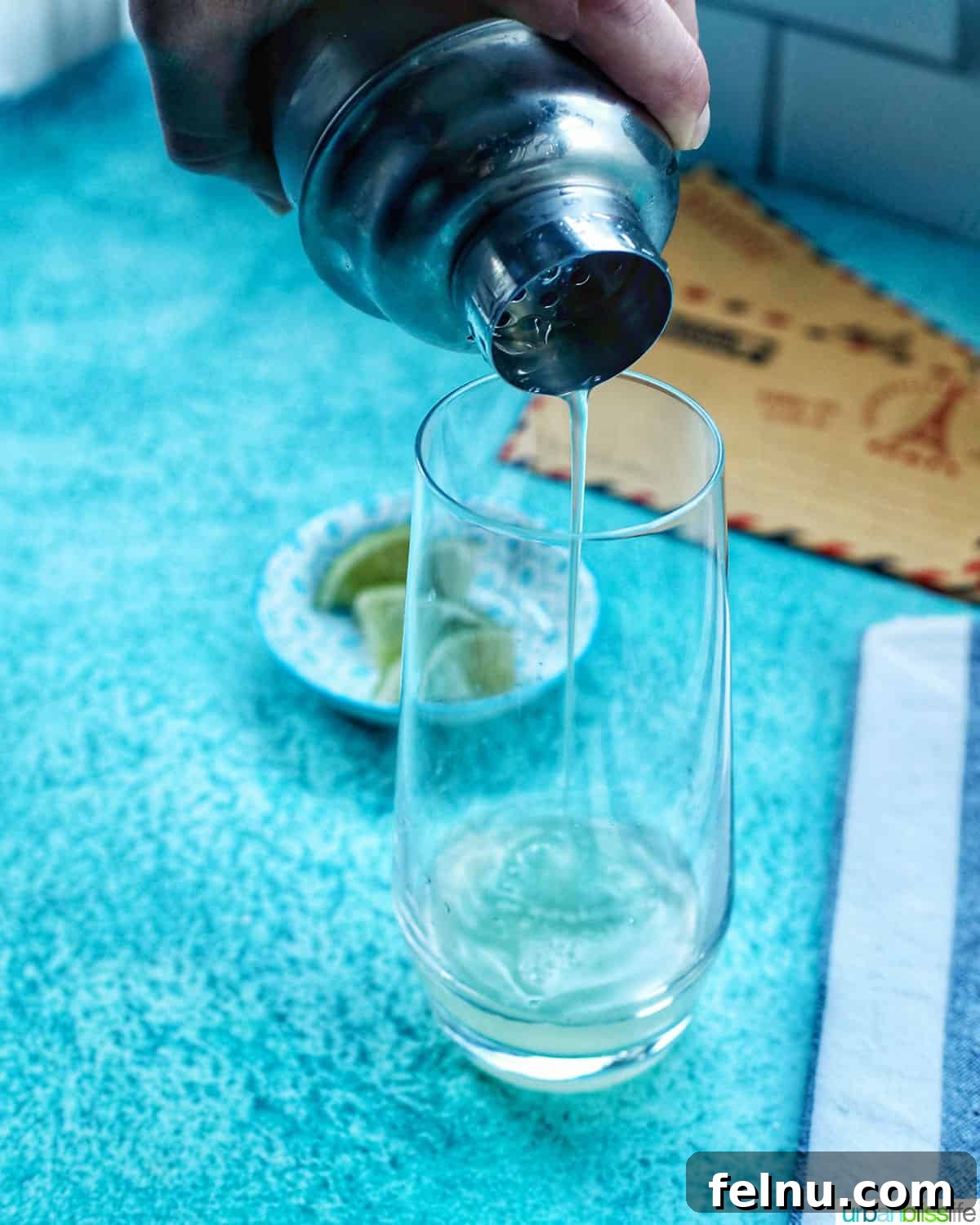First Class Flight 7 Straining the rum, lime, and syrup mixture into a highball glass.