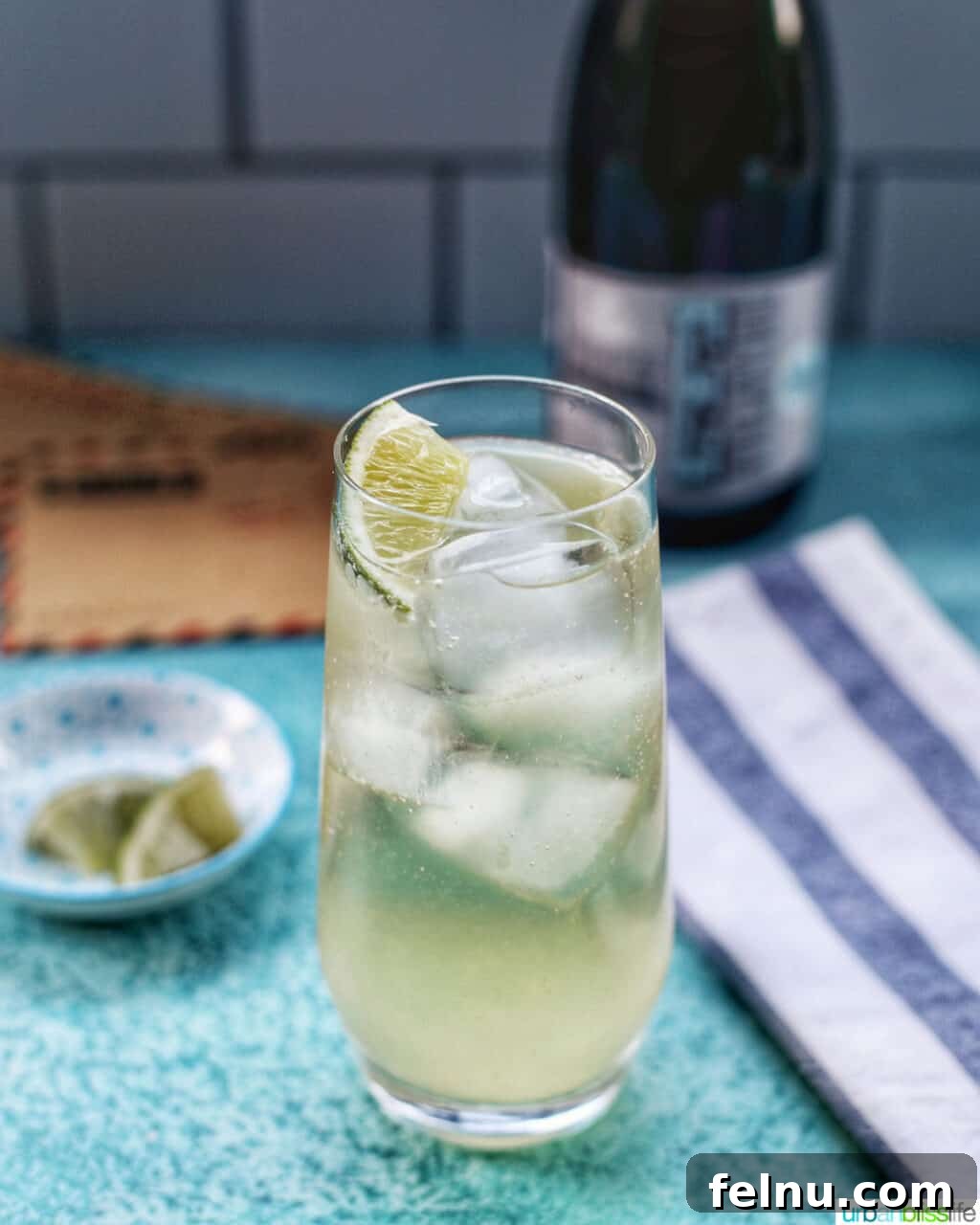 First Class Flight 9 Airmail Cocktail in a highball glass with a lime wedge.