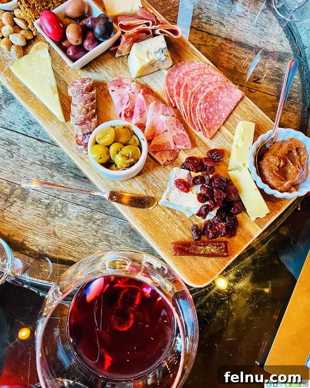 Fullerton Uncorked 11 A luxurious cheese and charcuterie board, perfectly paired with a glass of Fullerton's rich Pinot Noir, set in a cozy wine bar ambiance.