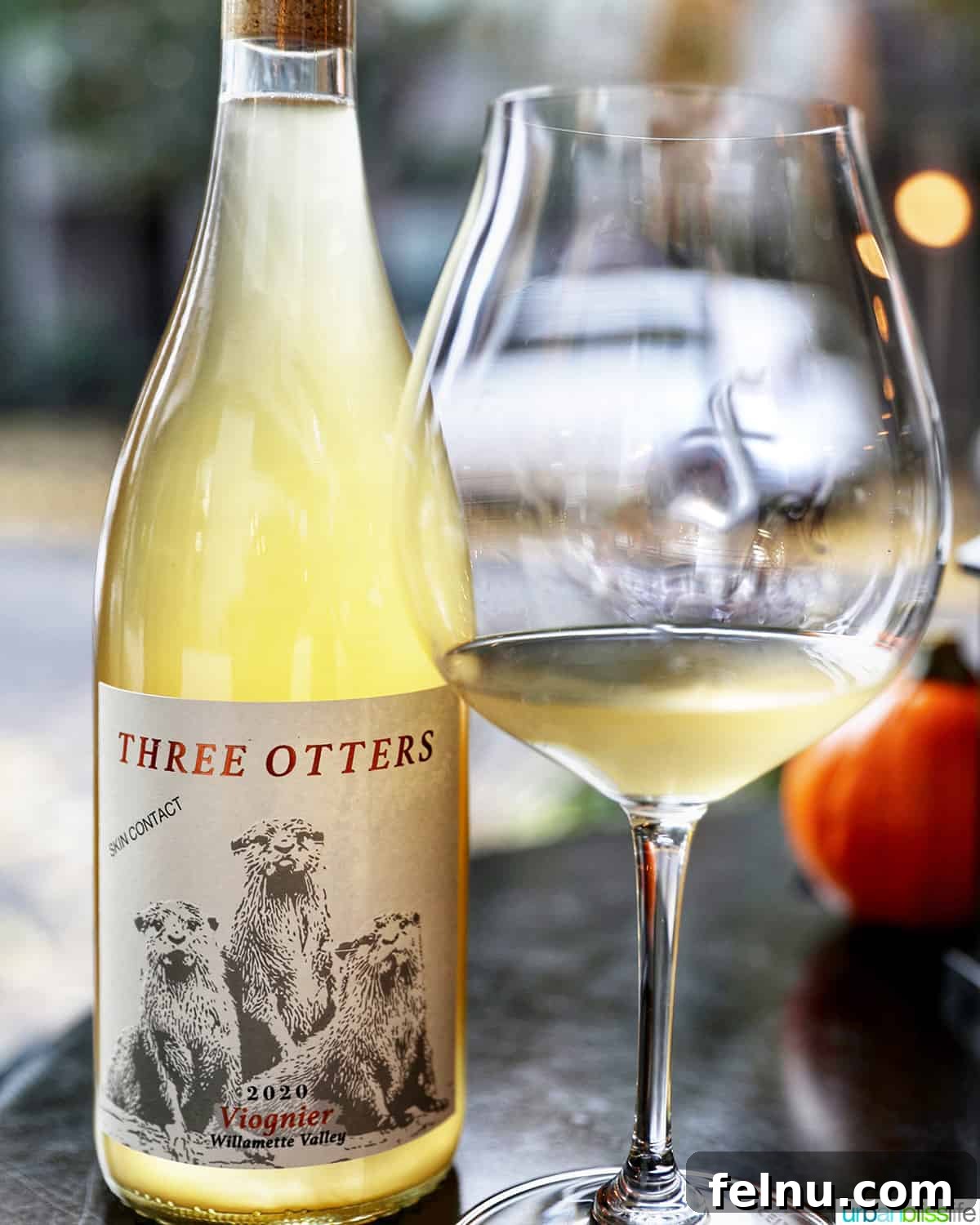 Fullerton Uncorked 6 Fullerton Wines' Three Otters Viognier, an 'orange' wine, presented in a bottle alongside a glass, highlighting its unique color.
