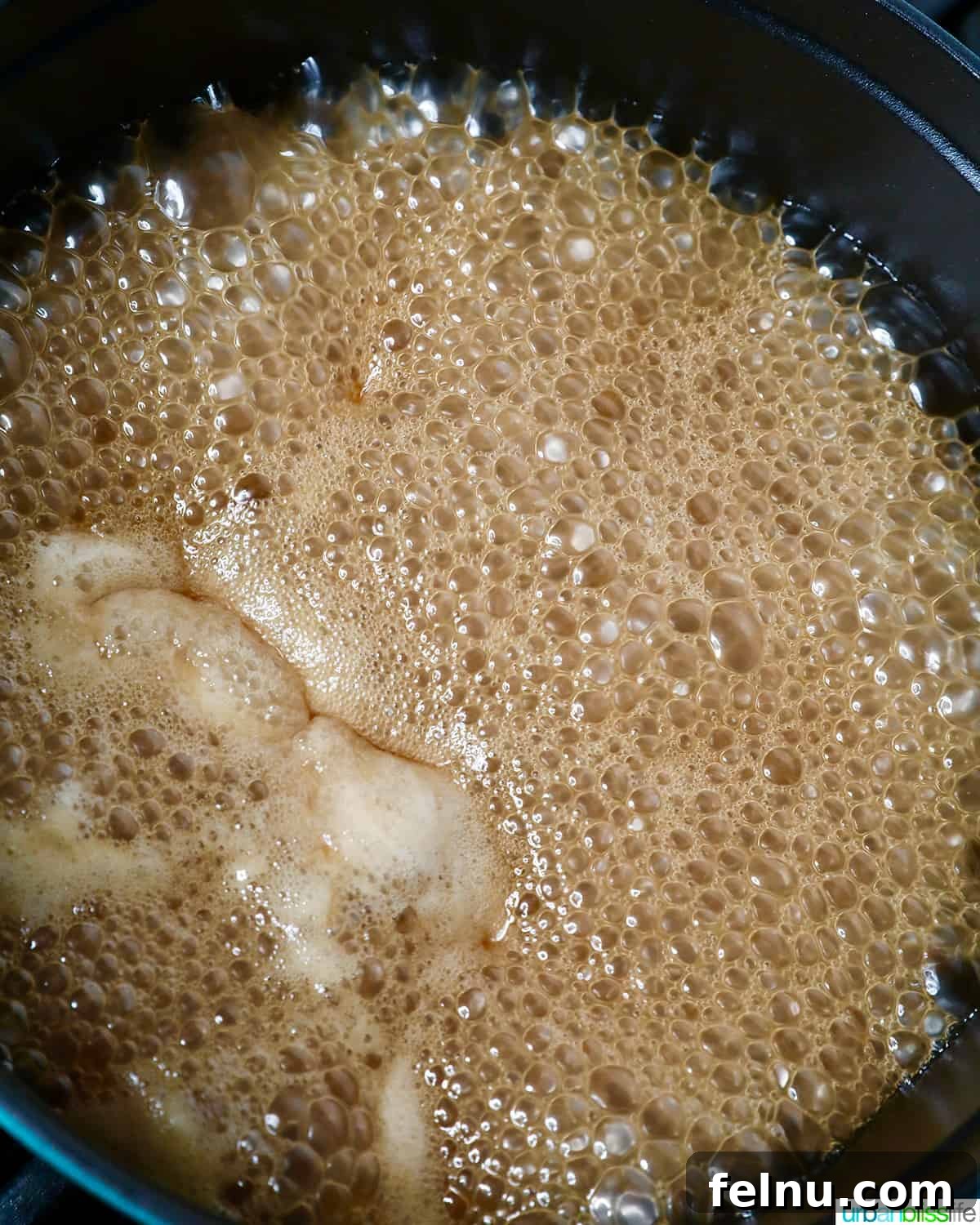 The coconut milk and brown sugar mixture simmering gently for Filipino Biko.