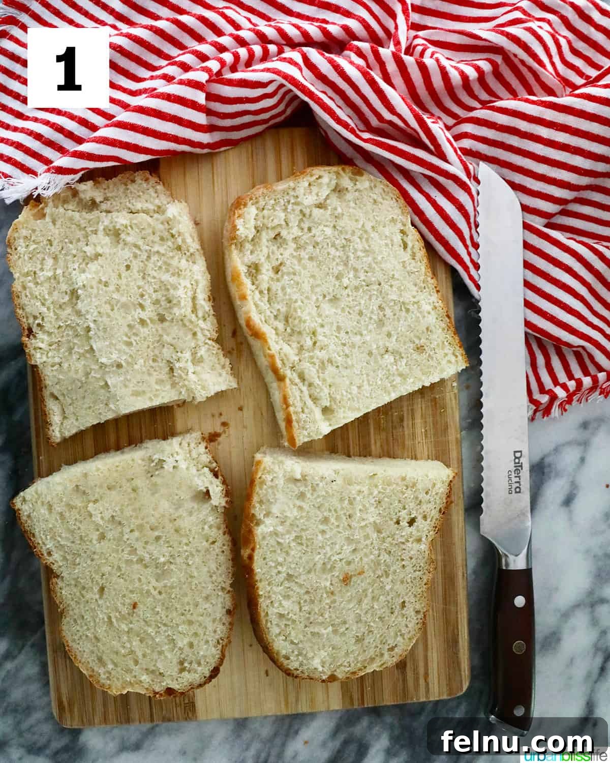 Crispy Air Fryer Pizza 5 A loaf of French bread expertly sliced into four even halves on a cutting board next to a bread knife and a red striped napkin.