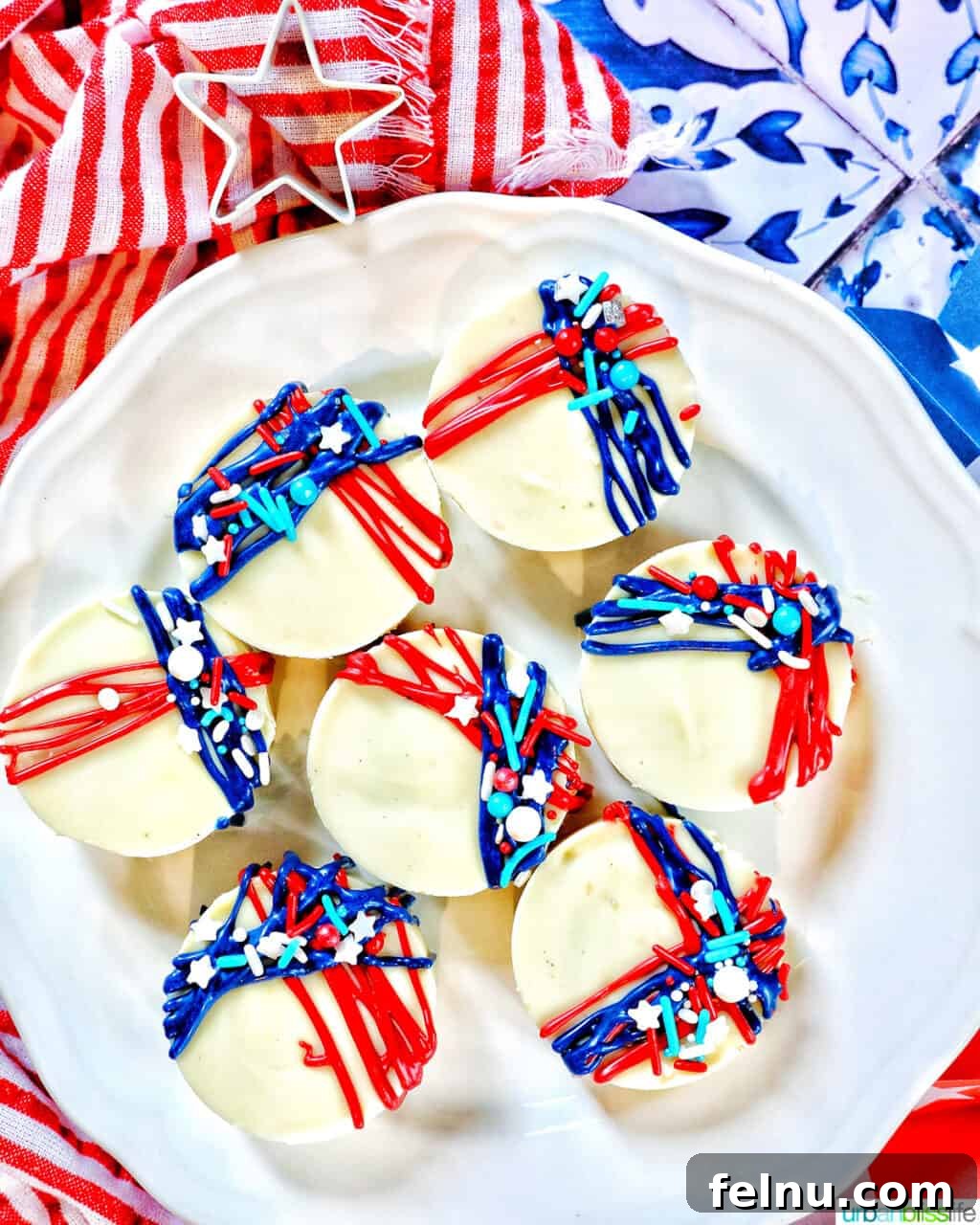 Fourth of July-Themed Oreo Delights 3 White chocolate covered Oreo cookies with red and blue frosting and sprinkle decorations.