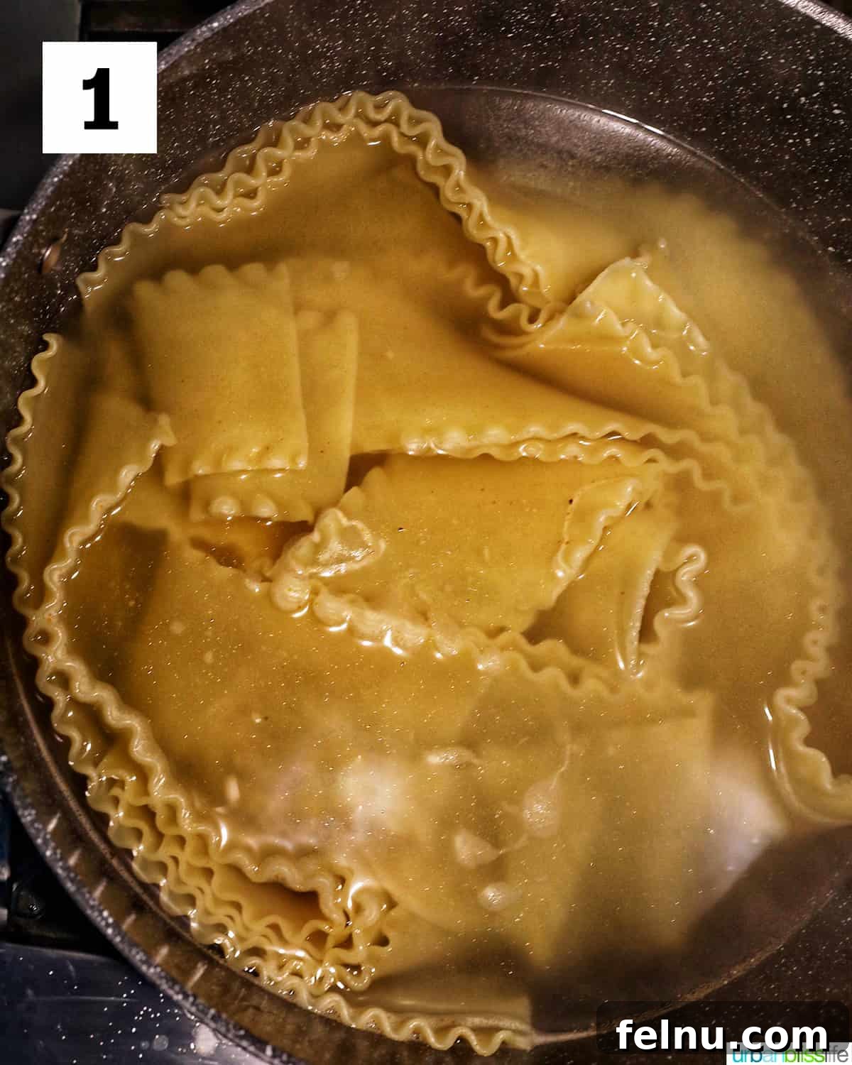Creamy Vegan Lasagna 5 lasagna noodles cooked in a large pot of water covering the noodles.