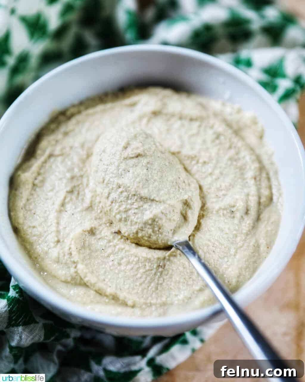 Creamy Vegan Cashew Cheese 2 A beautifully presented bowl of creamy Vegan Cashew Cheese, ready to be enjoyed with a spoon, accompanied by a stylish green and white napkin.