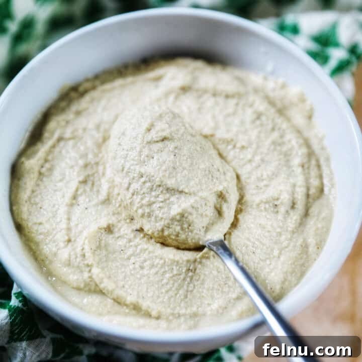 Vegan Cashew Cheese in a bowl with a spoon and green patterned napkin.
